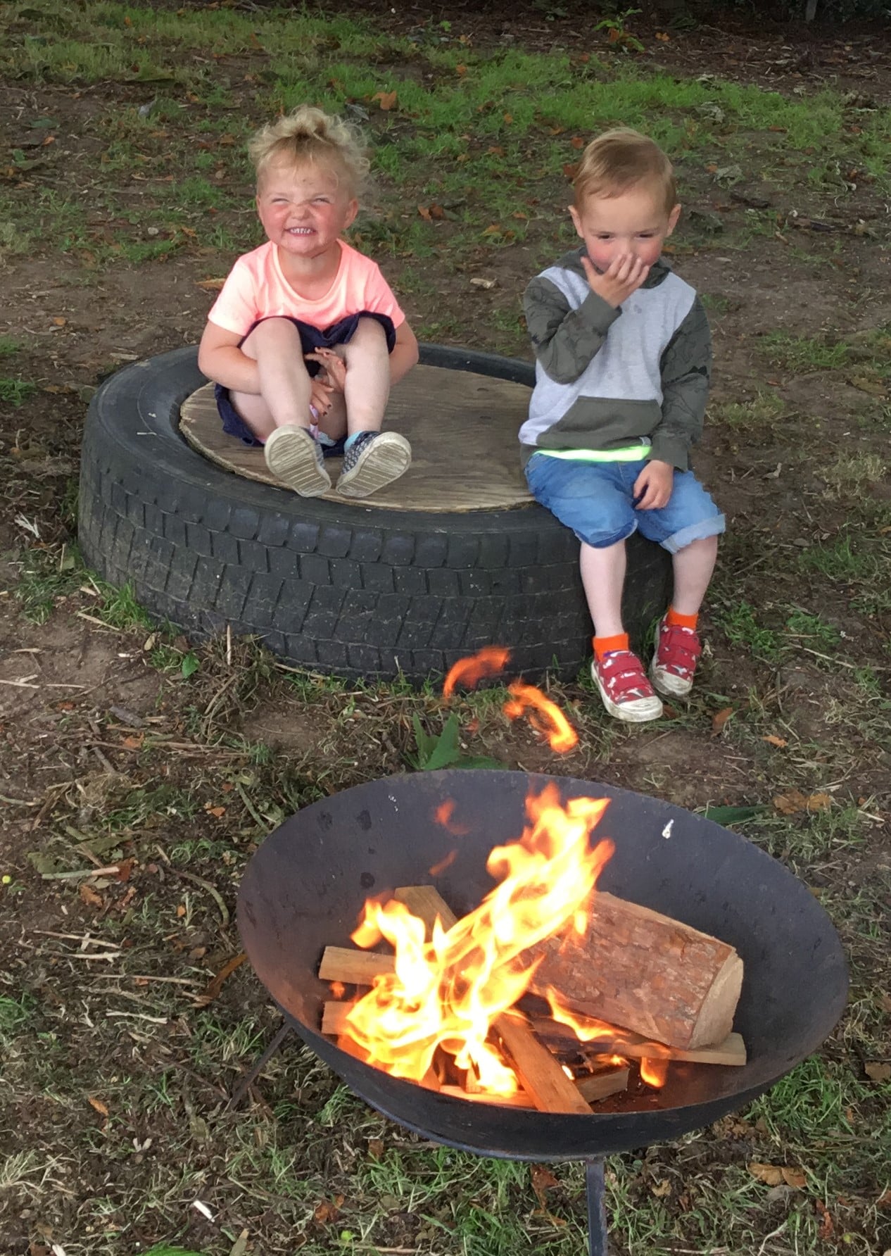 Fire pit at Forest School Two children sit a safe distance from a fire pit