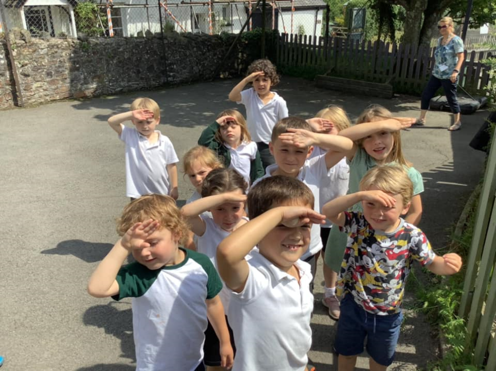 A small group of children shielding their eyes in the sunlight