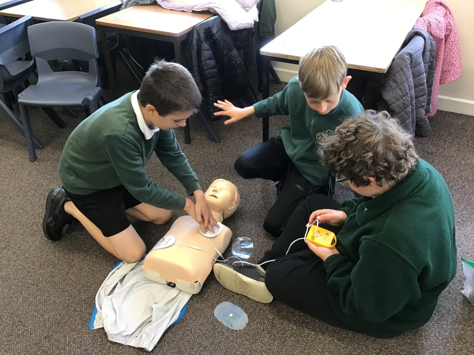 Children performing first aid on a resuscitation device